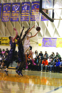 Lone Pine’s Garrett Sullivan ends a fast-break with 2 points on Tuesday, dragging two Scorpions along for the ride. Photo courtesy: Murphy.