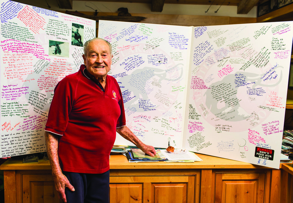 Dave McCoy standing in front of a rather large birthday card(s). He turns 100 Monday.