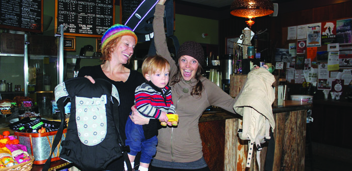 Left to right: Crystal Medhurst, Wade Medhurst, and Stellar Brew owner Andrea Walker show off donations to carrythefuture.org, a nonprofit that provides baby carriers to refugees from Syria. Anyone wishing to donate a gently-used soft structured baby carrier to be sent to refugees in Greece can drop off any time at Stellar Brew, or visit www.carrythefuture.org. Photo courtesy: Rea.